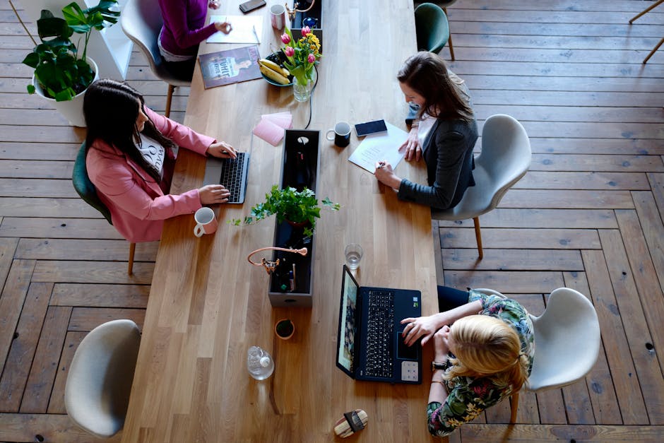 Overhead view of diverse women professionals working in a modern office setting, fostering collaboration and teamwork