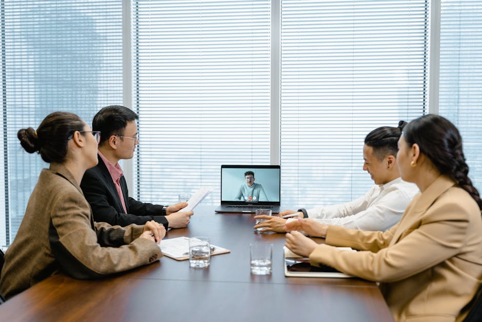 Business meeting with video call setup, highlighting teamwork and communication in a modern office environment